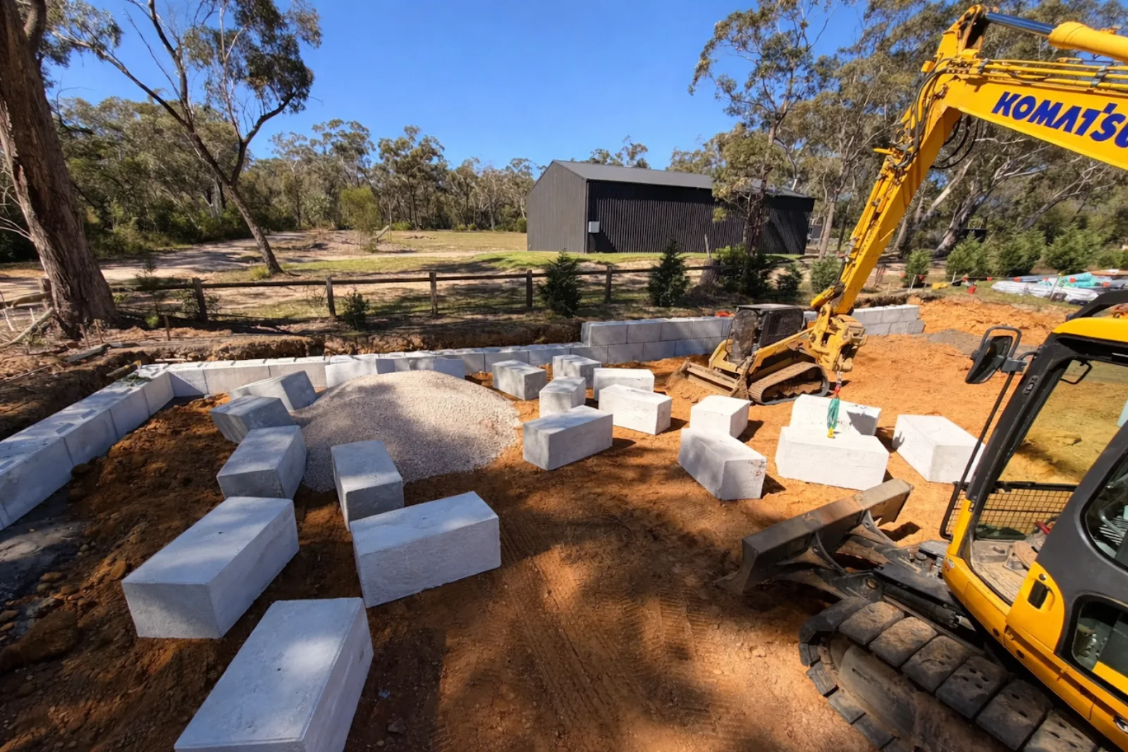 Symon precast concrete blocks being installed on a rural NSW site using a Komatsu excavator